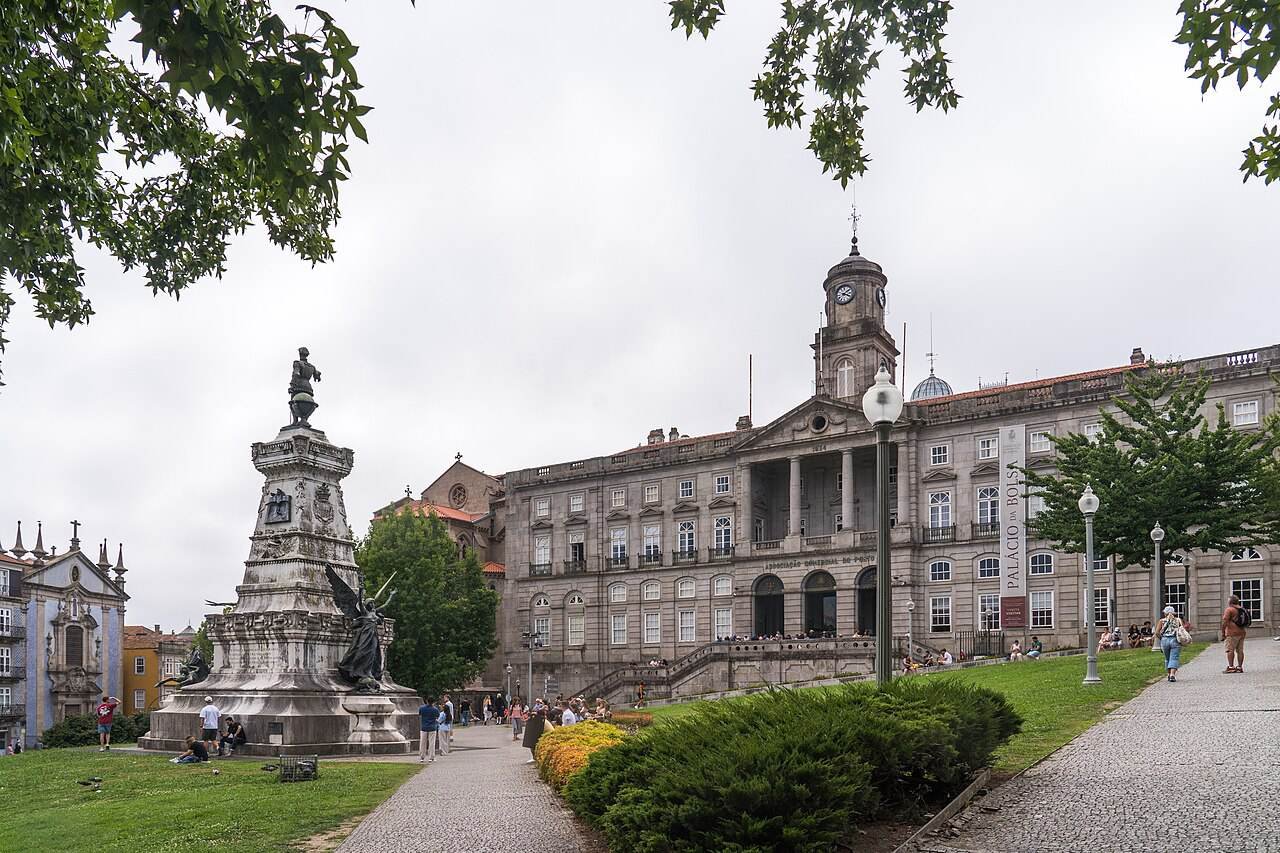 The neoclassical façade of the Palácio da Bolsa behind a garden and statue
