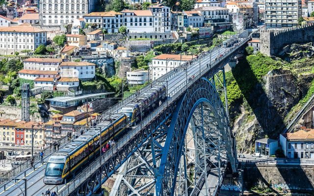 A metro tram crossing the upper deck of the Dom Luís I Bridge above the Douro