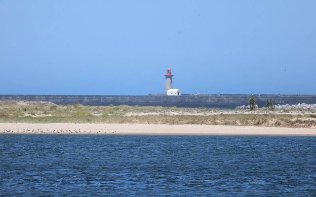 A small lighthouse at the end of a breakwater where the Douro meets the Atlantic