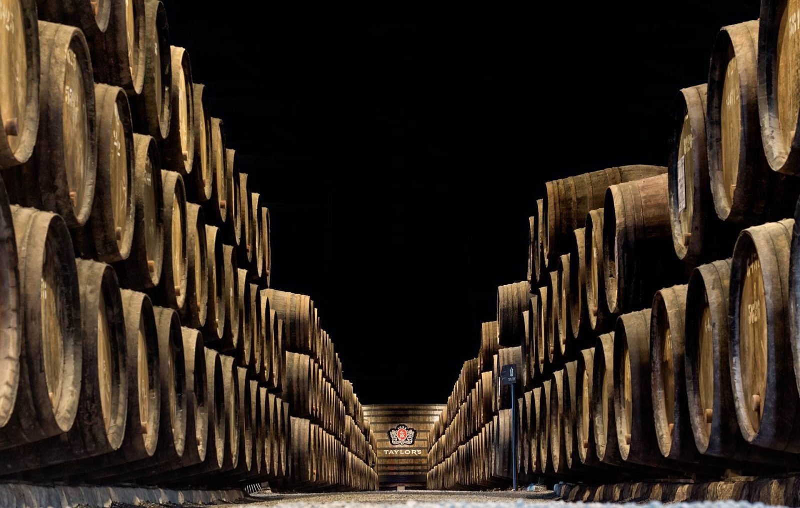 Long rows of oak port casks inside a cellar in Vila Nova de Gaia