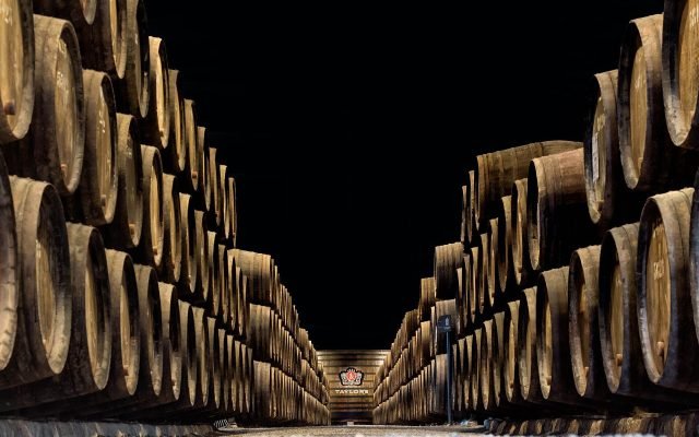 Long rows of oak port casks inside a cellar in Vila Nova de Gaia