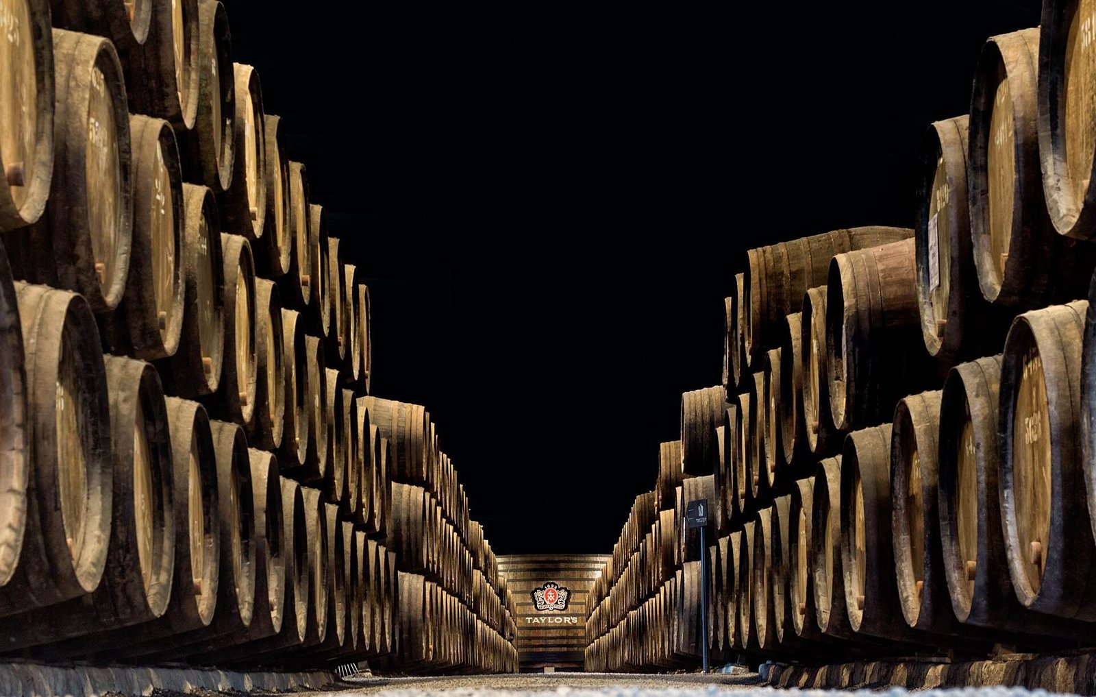 Long rows of oak port casks inside a cellar in Vila Nova de Gaia