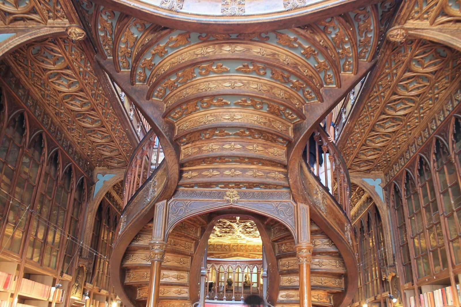 The carved wooden interior and forked staircase of Livraria Lello