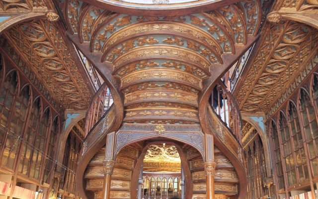 The carved wooden interior and forked staircase of Livraria Lello