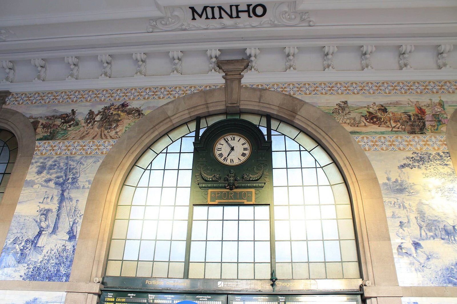 Blue and white azulejo tile panels and an arched window in the hall of São Bento station