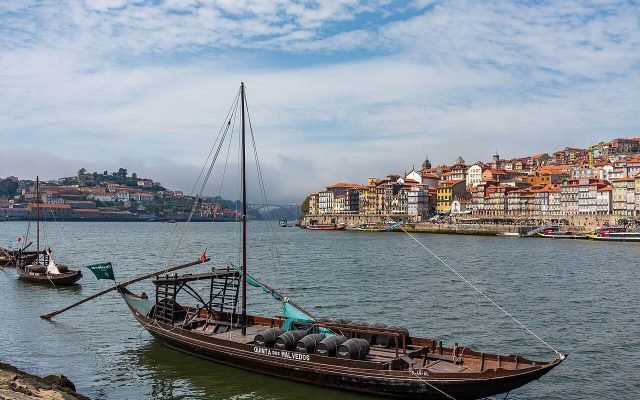 A traditional wooden rabelo boat on the Douro with Porto’s riverside behind