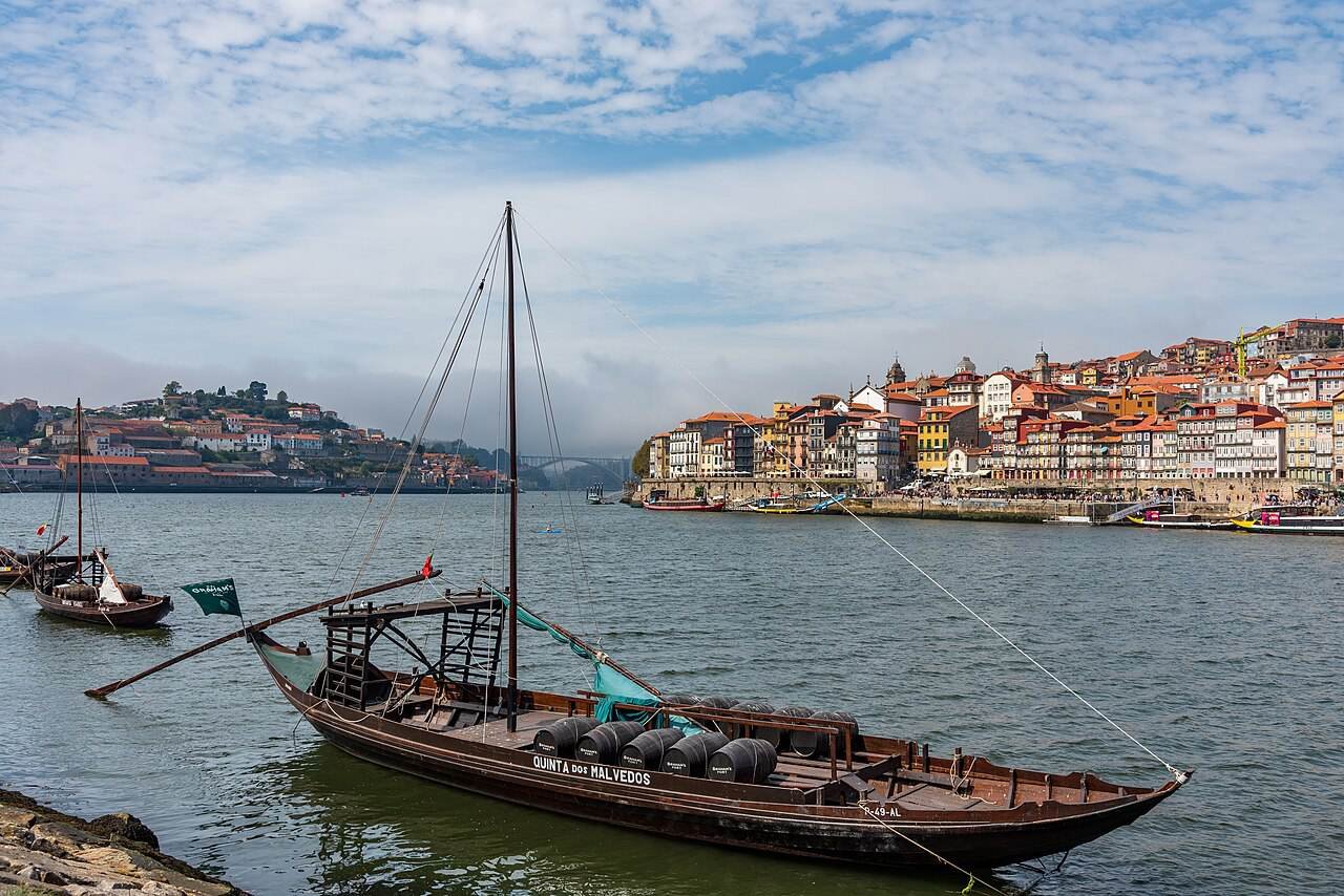 A traditional wooden rabelo boat on the Douro with Porto’s riverside behind