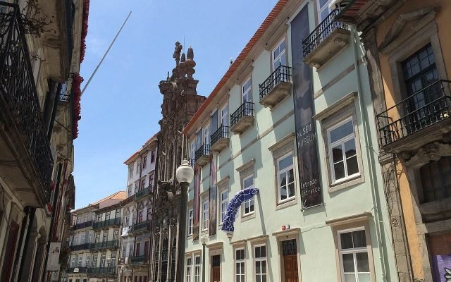 Pedestrians on Rua das Flores, lined with tall tiled and painted buildings
