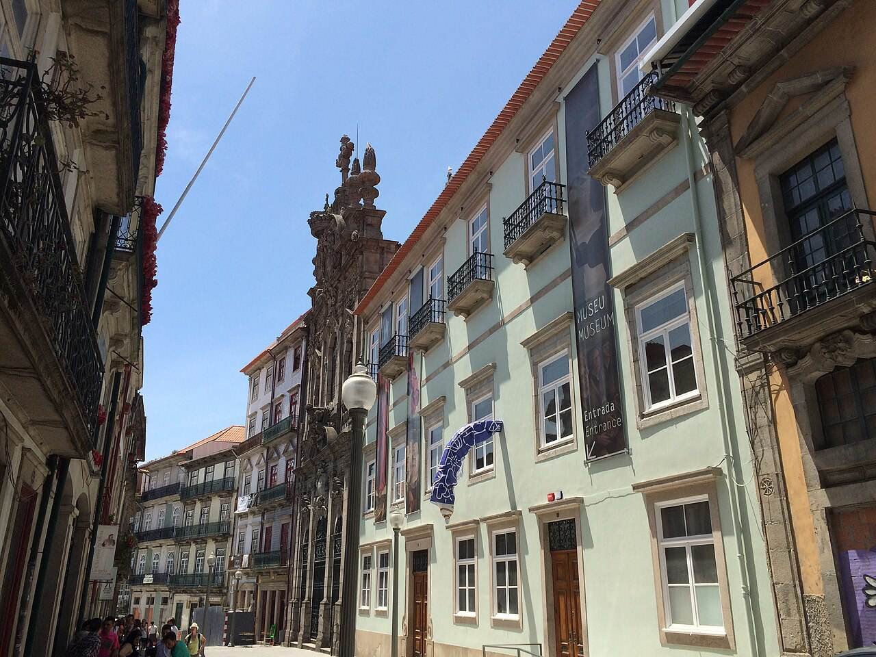 Pedestrians on Rua das Flores, lined with tall tiled and painted buildings